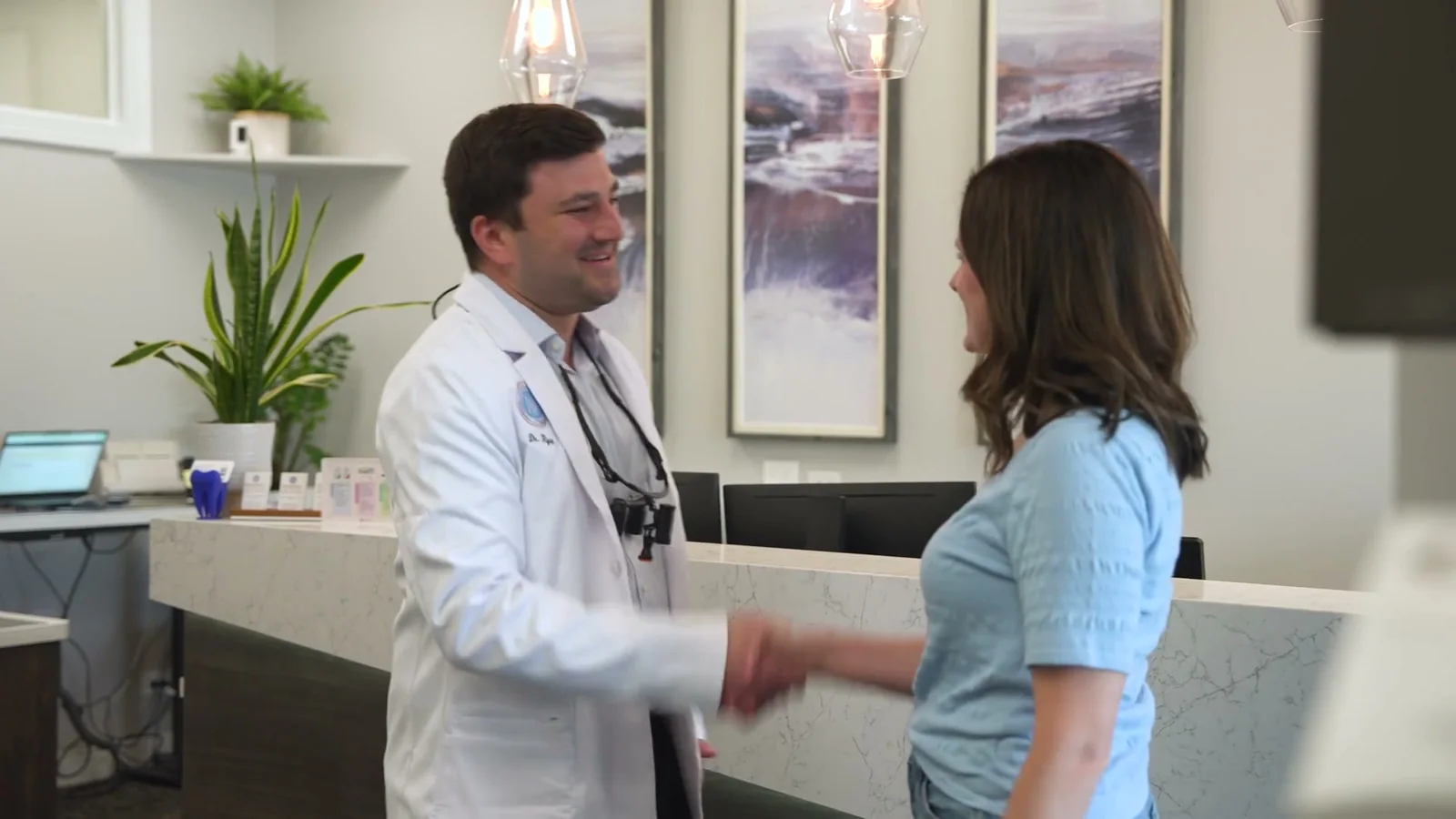 Dr. Ryan Bogard greeting a patient at the front desk of Markiewicz Dental