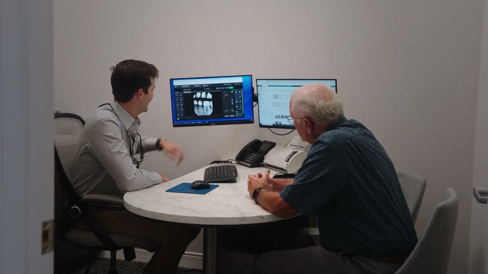 A Markiewicz Dental dentist reviewing a patient’s X-rays with them at a consultation table